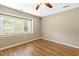 This well-lit bedroom features hardwood floors, neutral walls, and a ceiling fan at 12 Poppy Trl, Durham, NC 27713