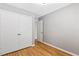 Neutral bedroom featuring gray walls, hardwood flooring, and double closet doors at 12 Poppy Trl, Durham, NC 27713