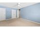 Light blue bedroom featuring neutral carpet, a ceiling fan, and white closet doors at 12 Poppy Trl, Durham, NC 27713