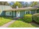 A charming one-story green house with manicured shrubs lining the walkway at 12 Poppy Trl, Durham, NC 27713