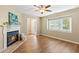 Bright living room featuring a fireplace, hardwood floors, a large window, and a front door at 12 Poppy Trl, Durham, NC 27713