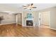 Open living room with fireplace, ceiling fan and wood flooring with view to other rooms at 12 Poppy Trl, Durham, NC 27713