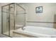 Bathroom with a soaking tub and seamless glass shower at 12808 Edsel Dr, Raleigh, NC 27613