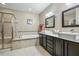 Primary bathroom with dual sinks, soaking tub, and glass shower at 12808 Edsel Dr, Raleigh, NC 27613