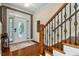 Inviting entryway featuring a decorative glass door, hardwood floors, and elegant staircase with wrought iron spindles at 12808 Edsel Dr, Raleigh, NC 27613