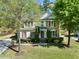 Well-manicured front yard with lush green grass and mature trees framing a charming two-story home at 12808 Edsel Dr, Raleigh, NC 27613