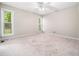 Large bedroom featuring ceiling fan, neutral carpet, and large windows for natural light at 1312 Rothes Rd, Cary, NC 27511