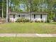 Charming single-story home with a cozy front porch and mature landscaping at 1312 Rothes Rd, Cary, NC 27511