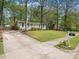 Well-maintained home featuring a spacious driveway and lush greenery at 1312 Rothes Rd, Cary, NC 27511