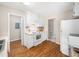 View of kitchen with white cabinets, appliances, wood-look floors and open floorplan at 1312 Rothes Rd, Cary, NC 27511