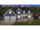 Charming two-story home featuring a 2-car garage, stone accents, a covered porch, and manicured landscaping at 133 Aleah Ct, Clayton, NC 27520