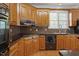 Traditional style kitchen with wooden cabinets, dark countertops, and mosaic tile backsplash at 133 Aleah Ct, Clayton, NC 27520