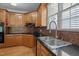 Traditional kitchen with wood cabinets, mosaic backsplash, and stainless steel sink beneath a window at 133 Aleah Ct, Clayton, NC 27520