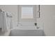 Bright bathroom featuring a soaking tub, window and white tile surround, providing a spa-like retreat at 140 Adams Pointe Ct Ct, Angier, NC 27501
