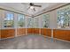 Bright sunroom with wood-paneled wainscoting, large windows, and a ceiling fan for added comfort at 140 Adams Pointe Ct Ct, Angier, NC 27501