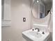 Bright bathroom featuring a white pedestal sink with vintage fixtures and a round mirror at 1403 Vickers Ave, Durham, NC 27707