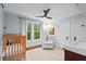 Bright Bedroom with a crib, soft chair, and ample natural light from a large window at 1403 Vickers Ave, Durham, NC 27707