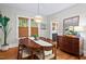 Bright dining room featuring a modern chandelier, hardwood floors, and three windows with woven shades at 1403 Vickers Ave, Durham, NC 27707