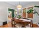 Bright dining room featuring a modern chandelier, hardwood floors, and three windows with woven shades at 1403 Vickers Ave, Durham, NC 27707
