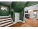 Stylish foyer with green walls, hardwood floors, staircase, and an open doorway to the living room with fireplace at 1403 Vickers Ave, Durham, NC 27707
