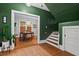 Stylish foyer with green walls, hardwood floors, a staircase, and an open doorway to the dining room at 1403 Vickers Ave, Durham, NC 27707