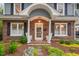 Inviting front porch with brick columns, white chairs, and colorful landscaping at 1403 Vickers Ave, Durham, NC 27707