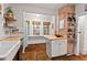 Bright kitchen featuring exposed brick, a built-in breakfast table, and subway tile backsplash at 1403 Vickers Ave, Durham, NC 27707