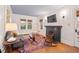 Cozy living room with a decorative fireplace, hardwood floors, comfortable seating, and natural light at 1403 Vickers Ave, Durham, NC 27707