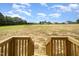 Expansive backyard view with open field and neighborhood homes under a bright, cloud-filled sky at 152 Royal Ave, Selma, NC 27576