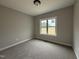 Cozy bedroom with neutral carpet and large window overlooking the yard at 152 Royal Ave, Selma, NC 27576
