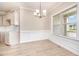 Well-lit dining room with wainscoting detail, chandelier, and view to front yard at 152 Royal Ave, Selma, NC 27576