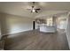 Open-concept living room featuring hardwood floors, a ceiling fan, and a view of the kitchen at 152 Royal Ave, Selma, NC 27576