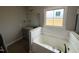 Primary bathroom featuring a soaking tub, granite countertops, and a window at 152 Royal Ave, Selma, NC 27576