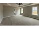 Large primary bedroom with tray ceilings, carpet, and natural light from two windows at 152 Royal Ave, Selma, NC 27576