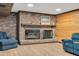 Finished basement with a brick fireplace, wood accents, and two comfortable blue armchairs at 1602 Lake Shore Dr, Dunn, NC 28334
