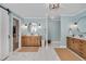 Beautiful bathroom showcasing a dual sink vanity, round mirror, light blue walls, and modern lighting at 1602 Lake Shore Dr, Dunn, NC 28334