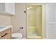 Retro bathroom featuring a corner shower with vintage tile and a toilet with a modern sink at 1602 Lake Shore Dr, Dunn, NC 28334