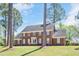 Classic brick home with well-maintained lawn, mature trees, and inviting front entrance with American flag at 1602 Lake Shore Dr, Dunn, NC 28334