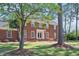 Beautiful two-story brick home featuring a manicured lawn and mature shade trees at 1602 Lake Shore Dr, Dunn, NC 28334
