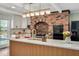 Bright kitchen showcasing a spacious island, quartz countertops, brick accent wall and modern appliances at 1602 Lake Shore Dr, Dunn, NC 28334