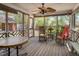 Relaxing screened-in porch with rocking chairs, dining table, ceiling fan, and natural light at 1602 Lake Shore Dr, Dunn, NC 28334