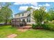 Well-maintained backyard featuring a wooden deck, brick patio, and a manicured lawn, ideal for outdoor living at 1604 Cane Creek Dr, Garner, NC 27529