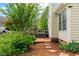 Landscaped backyard with a wooden deck, brick steps, and lush greenery, offering a private outdoor retreat at 1604 Cane Creek Dr, Garner, NC 27529