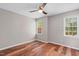 Well-lit bedroom with hardwood floors, ceiling fan, and two large windows at 1604 Cane Creek Dr, Garner, NC 27529