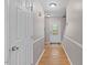 Hallway with hardwood floors that leads to the front door with decorative glass at 1604 Cane Creek Dr, Garner, NC 27529