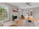 Charming living room featuring a fireplace, large windows, and hardwood floors at 1604 Cane Creek Dr, Garner, NC 27529