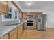 A view of the bright kitchen, featuring wood cabinets, stainless steel appliances, and light countertops at 1623 Alicary Ct, Cary, NC 27511