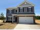 Charming two-story home with gray siding, black shutters, brick accents, and a two-car garage at 164 E Victory View. Ter, Smithfield, NC 27577