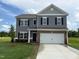 Charming two-story home featuring gray siding, brick accents, and a spacious two-car garage at 164 E Victory View. Ter, Smithfield, NC 27577