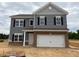 Charming two-story home with gray siding, brick accents, and a two-car garage at 164 E Victory View. Ter, Smithfield, NC 27577